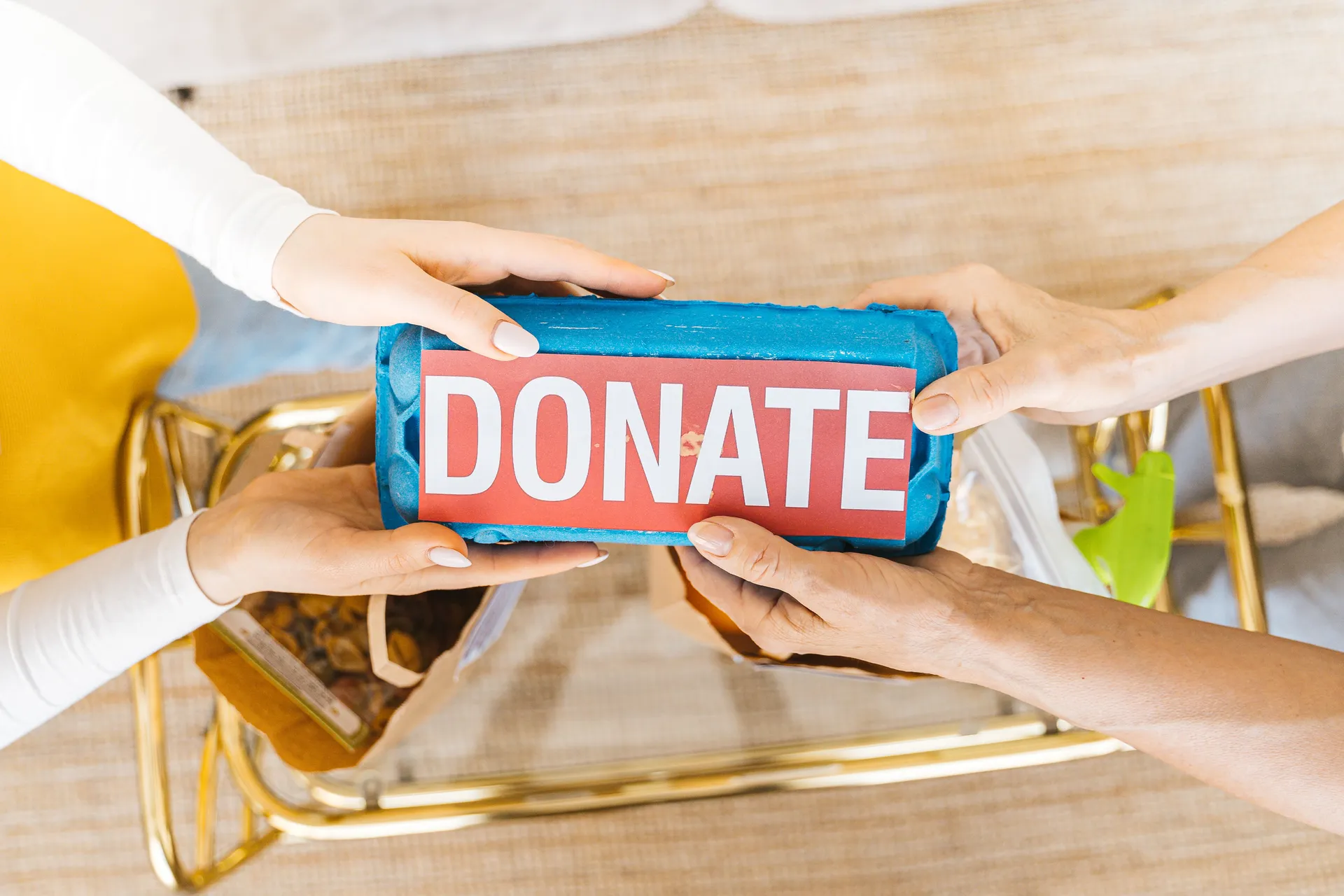 Hands holding a donation to support the REAL DEAL mission