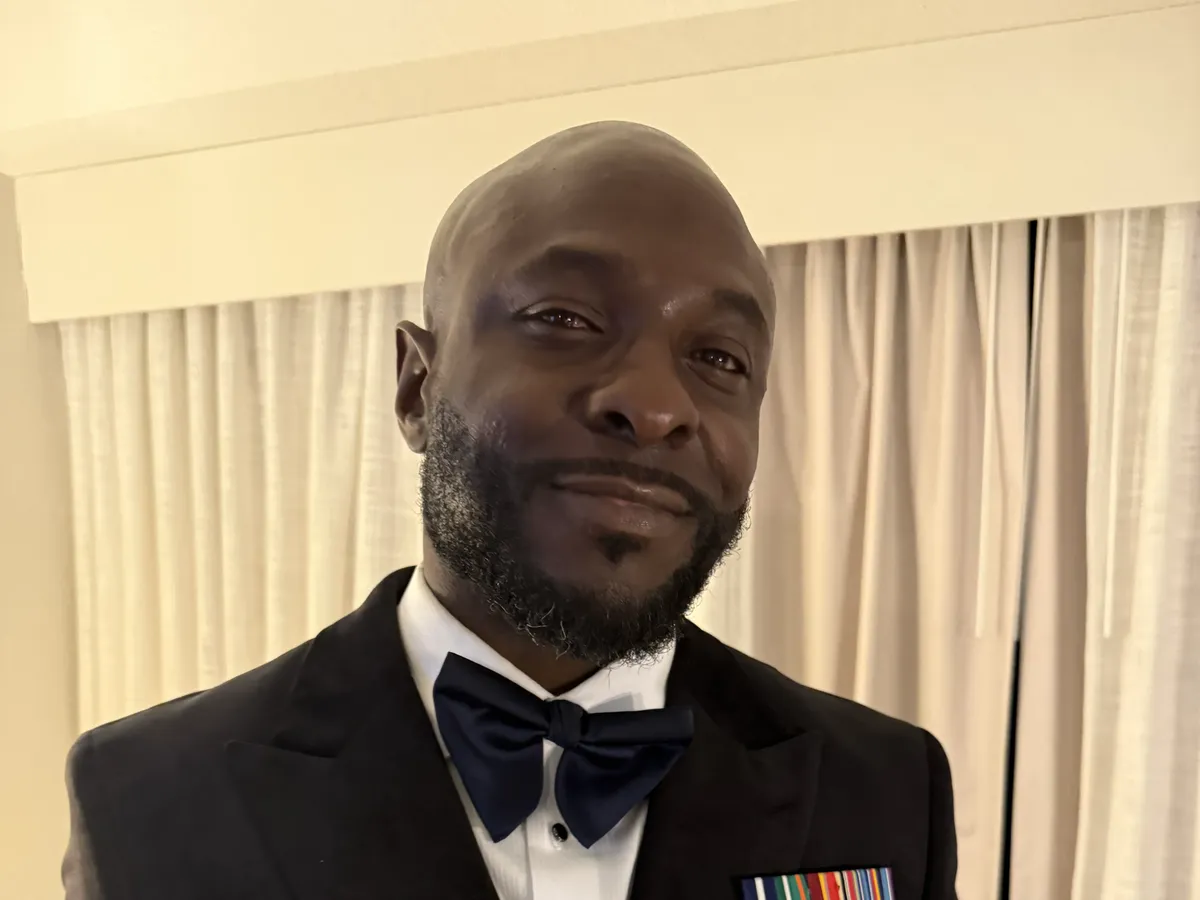 Aubrey McDade Jr. smiling in a tuxedo with his service ribbons